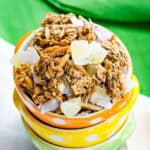 Looking down at three stacked bowls with tropical granola in the top one.