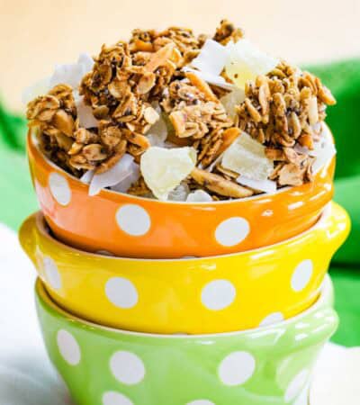 Three stacked bowls polka dot with the top one filled with tropical granola.
