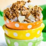 Three stacked bowls with granola with dried pineapple and coconut flakes with text overlay that says "Tropical Granola".