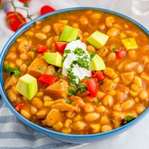 White turkey chili with toppings in a blue bowl.