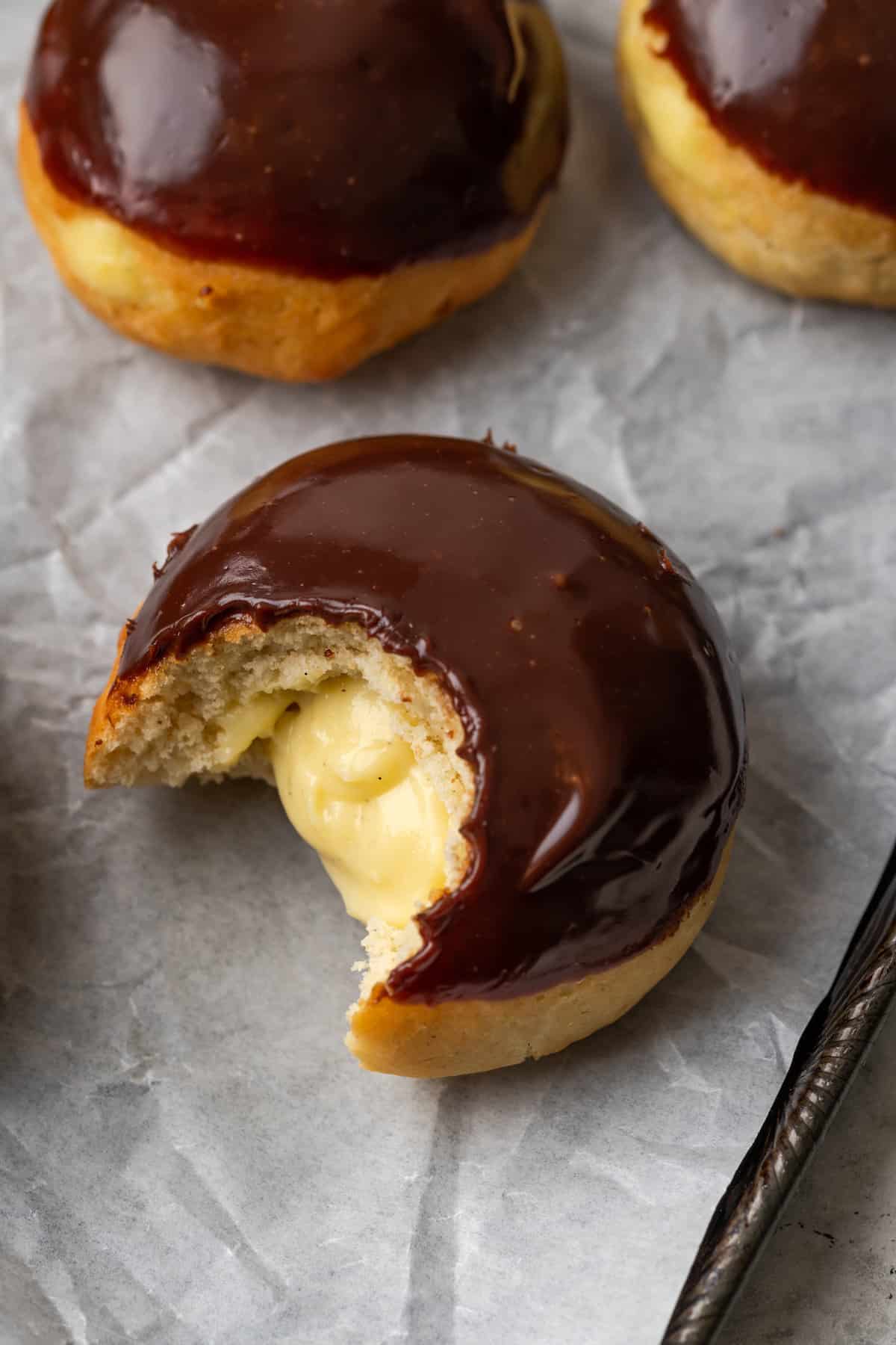 A tray of cream-filled gluten-free Boston Cream Pie donuts.