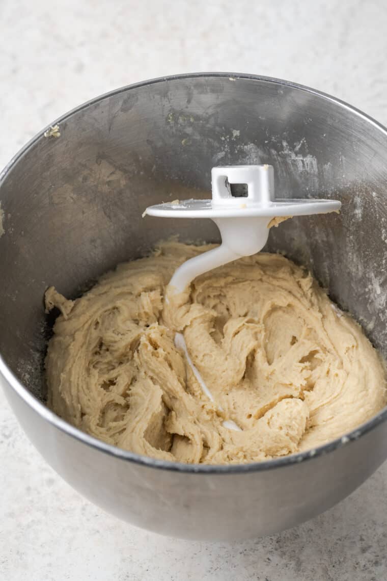A pastry hook mixes a batch of dough.