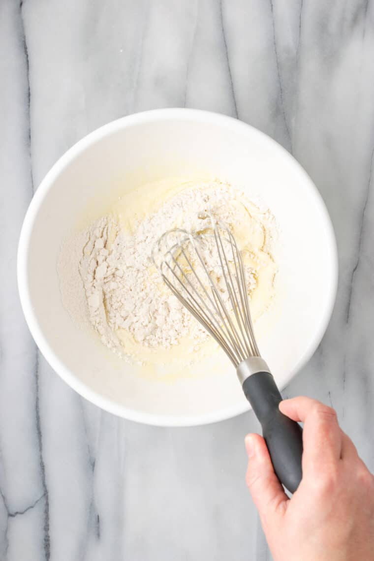 Whisking flour into pancake batter.