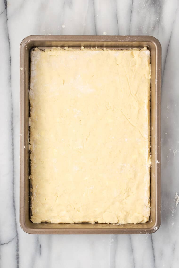 A layer of gluten-free dough in a pan.