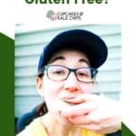 A photo of woman in a hat and glasses eating a toasted marshmallow overlaid on a green and white background with green text that says "Are Marshmallows Gluten Free?".