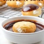 A round filled donut floating upside down in a bowl of chocolate glaze in front of a rack with more donuts on it with text overlay that says "Quick & Easy Chocolate Glaze".