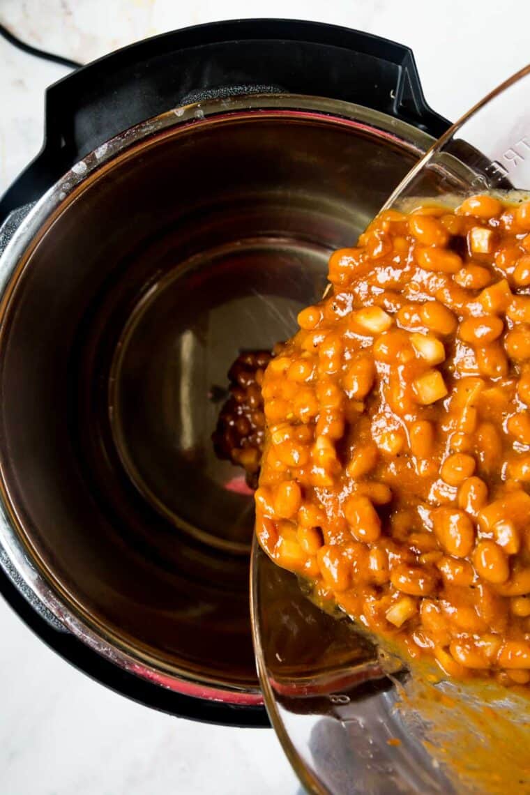 Baked beans being poured into an Instant Pot.