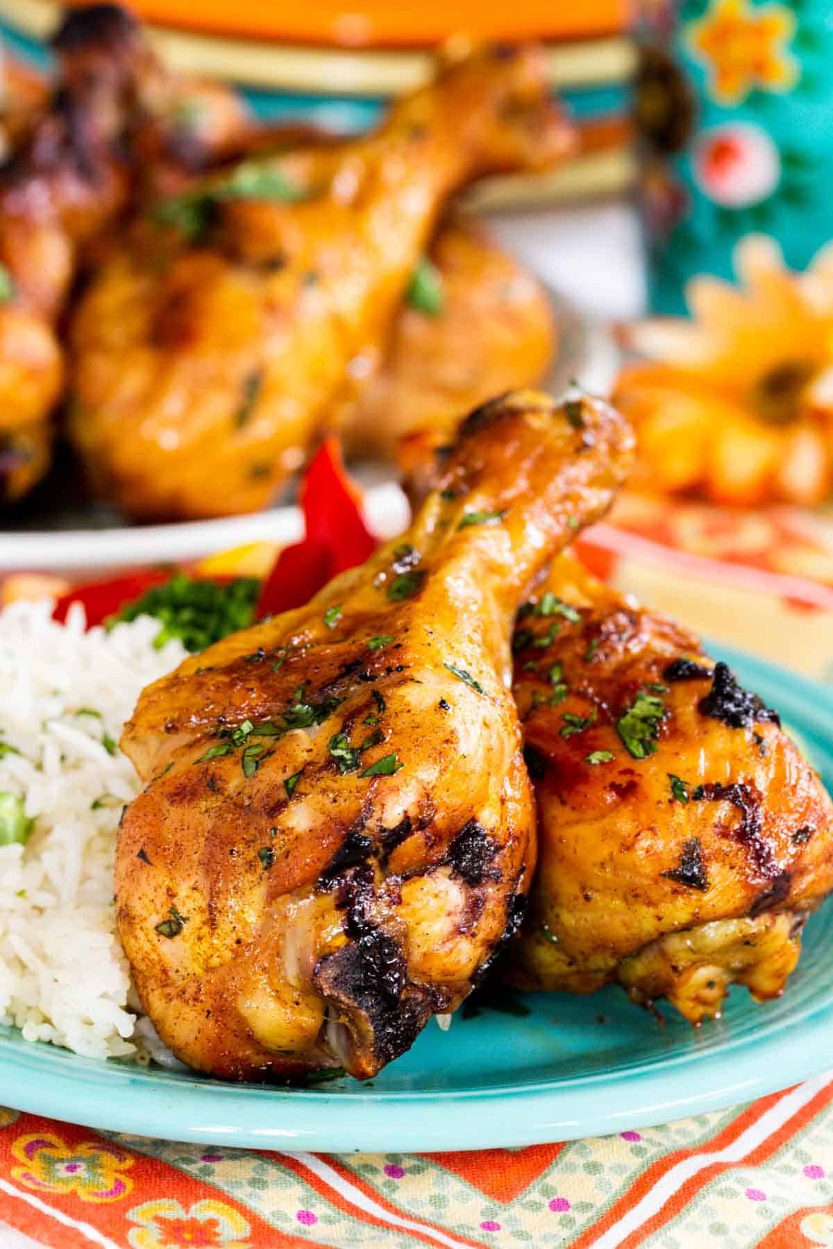 Grilled tandoori chicken legs on a plate with rice.