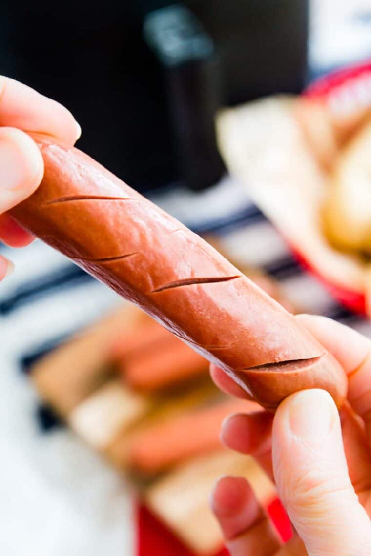 Close up of a hot dog with cuts in it.