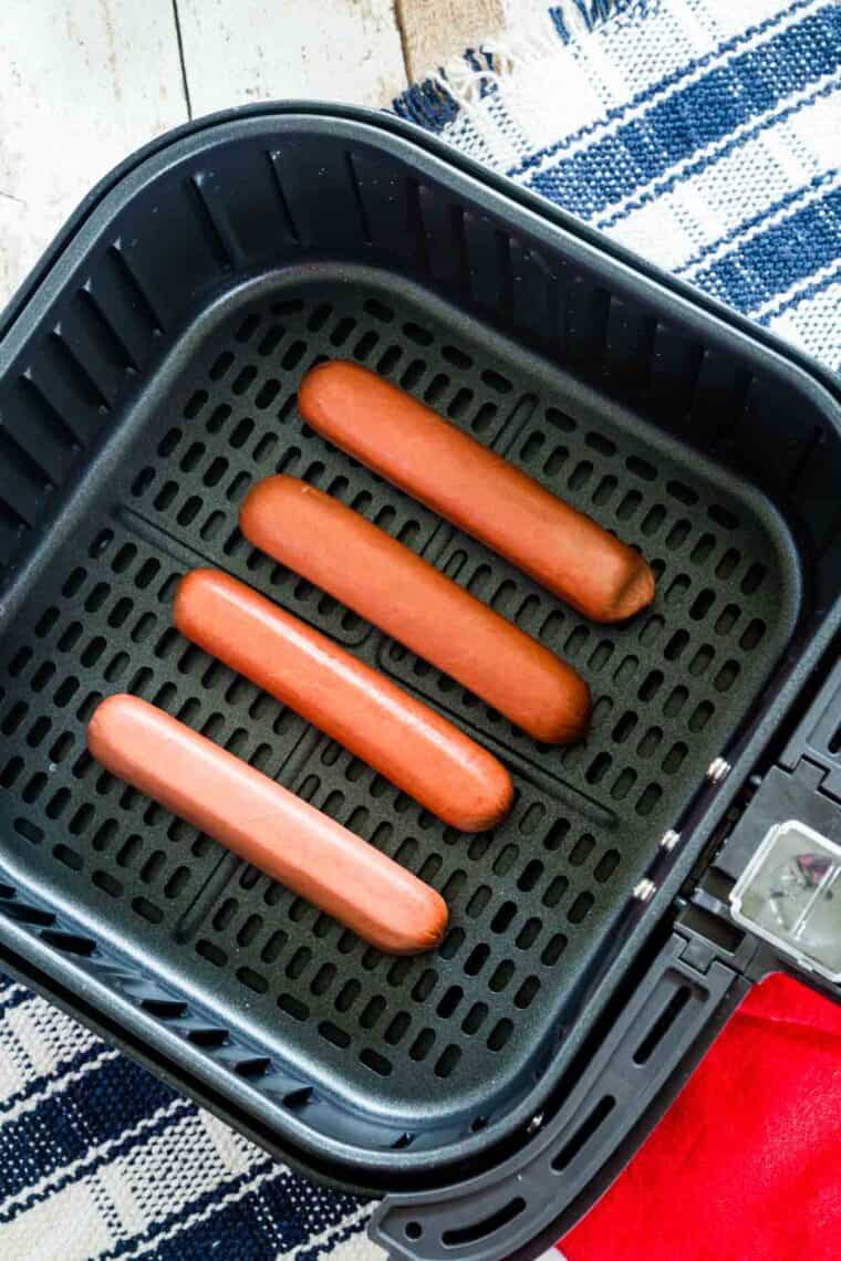 Hot dogs are placed in an air fryer.