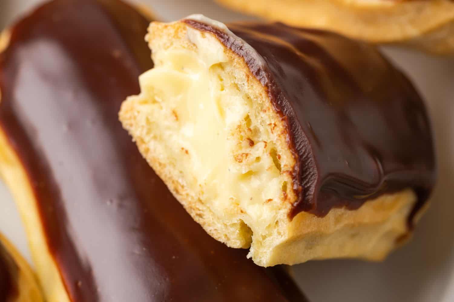 A closeup of the vanilla pastry cream filling in an eclair that's been cut in half.