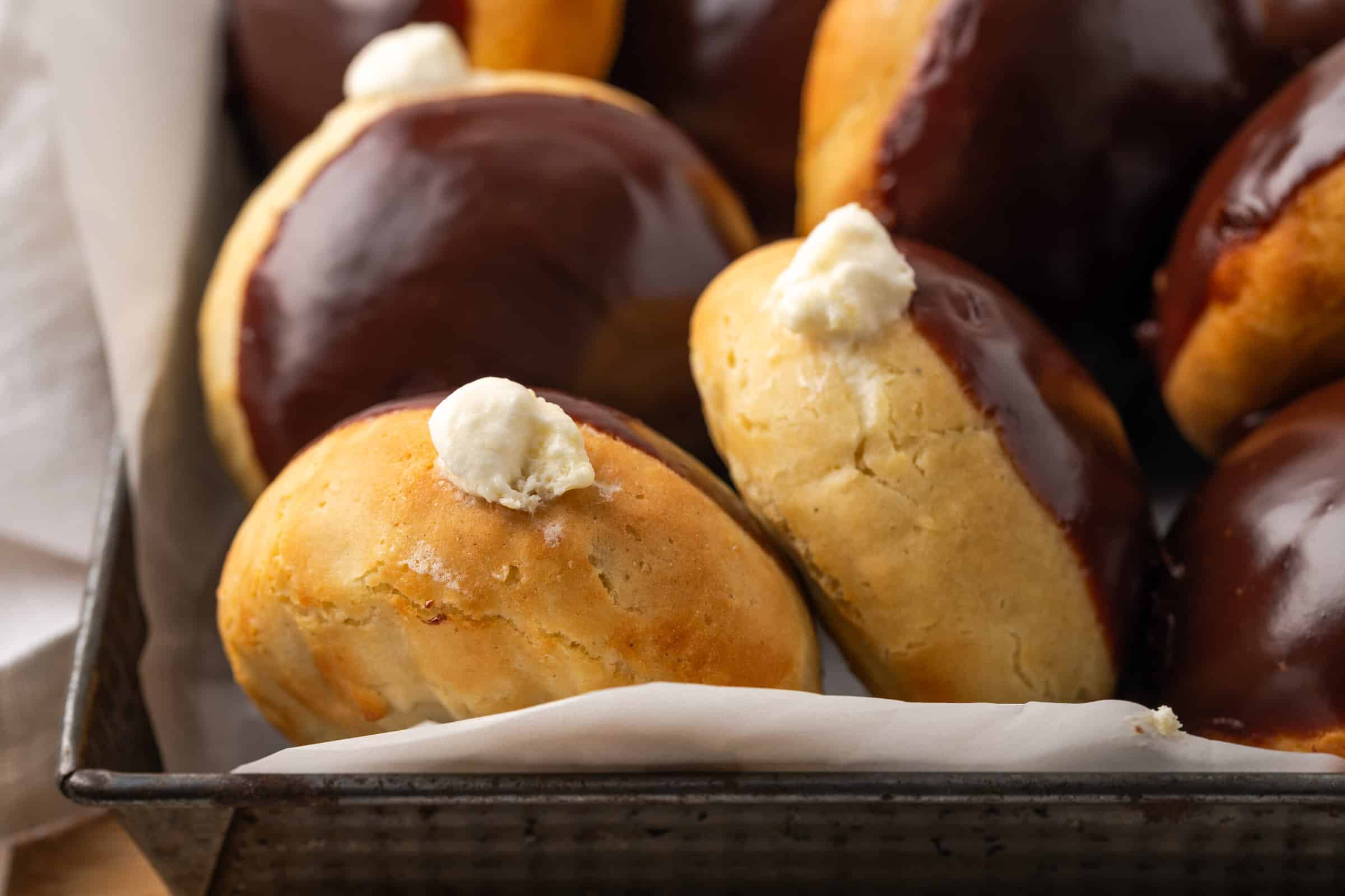 Gluten-free bismark donuts are shown together with chocolate glaze and pastry cream.
