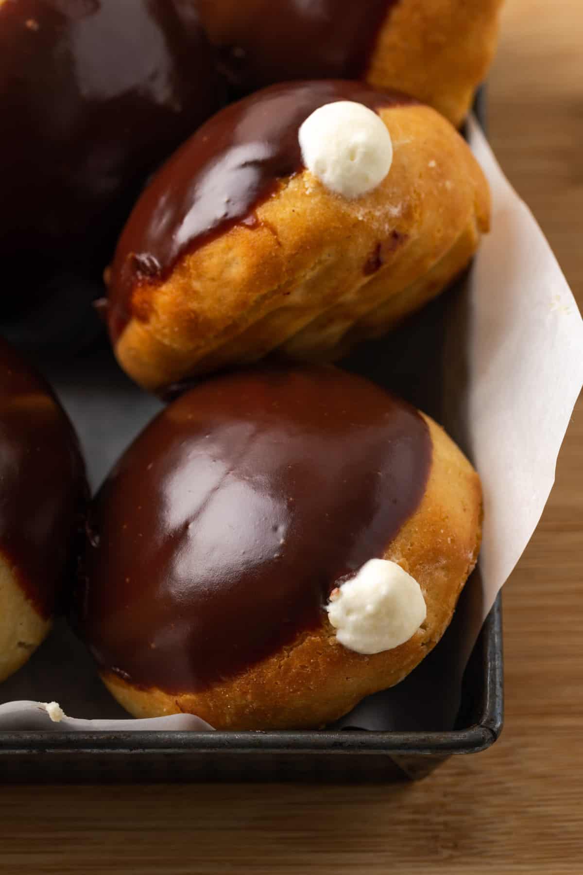 Gluten-free bismark donuts are shown together with chocolate glaze and pastry cream.