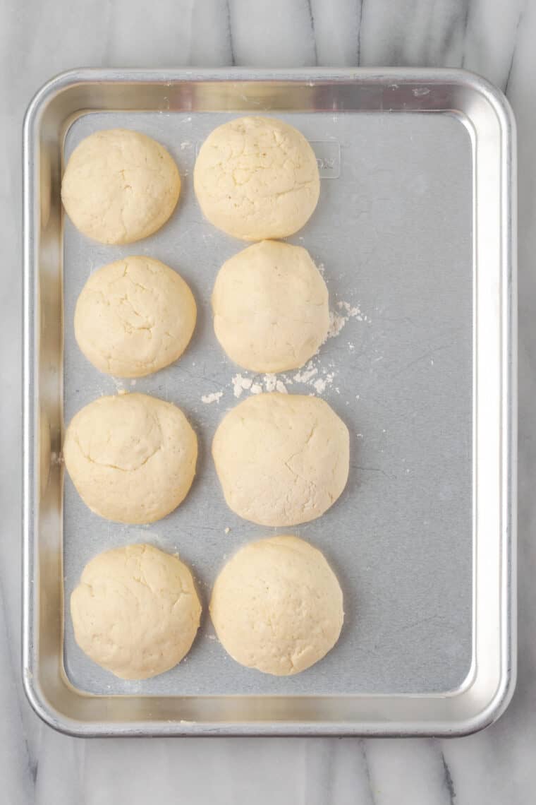 Balls of gluten-free naan dough are shown on a baking sheet.
