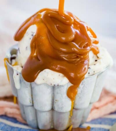 A bowl of ice cream topped with caramel sauce.
