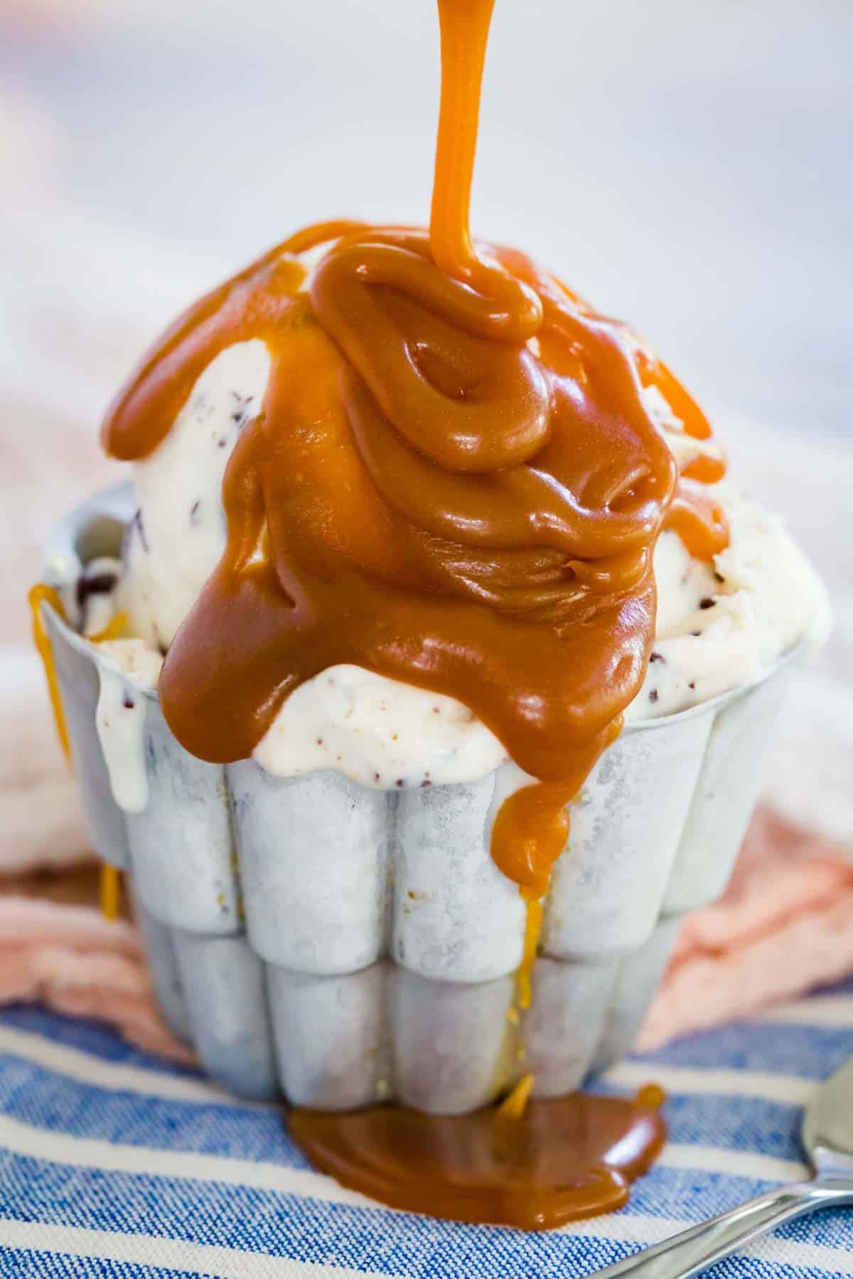 A bowl of ice cream topped with caramel sauce.