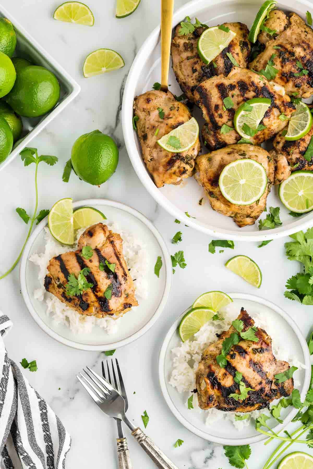 Cilantro lime chicken on rice on plates with a bowl of chicken.