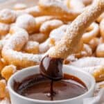 One funnel cake fry being dipped in chocolate sauce with text overlay that says "Gluten Free Funnel Cake Fries".