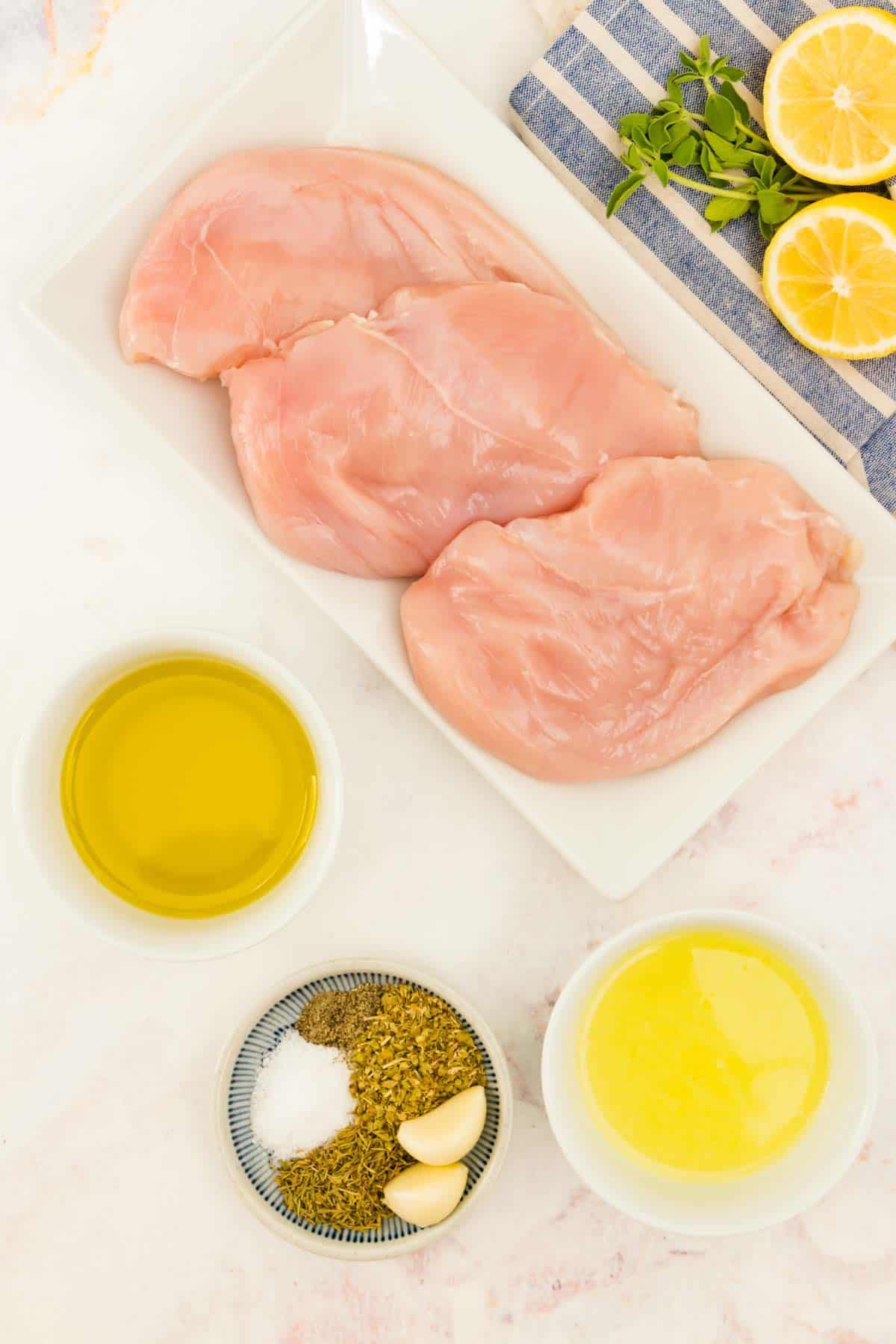 Ingredients for Greek grilled chicken - chicken, olive oil, spices, lemon juice.
