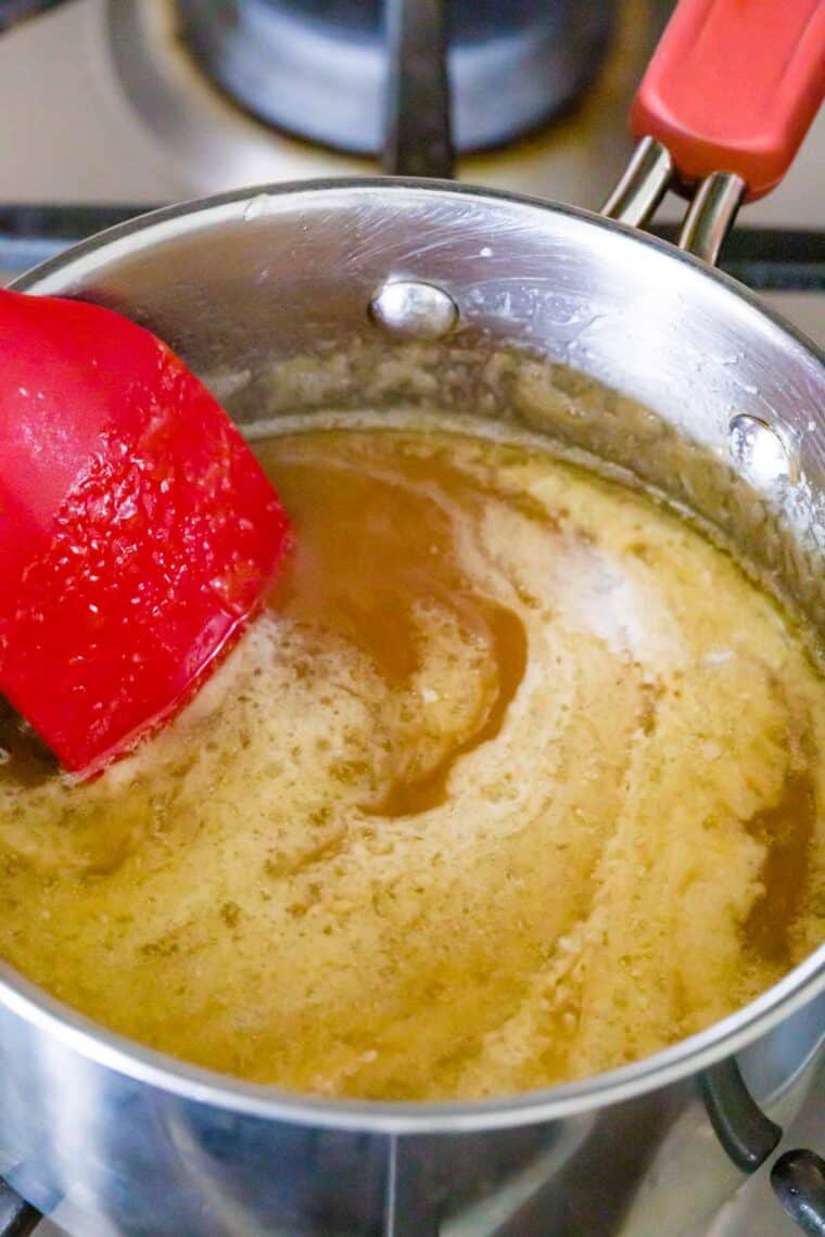 Stirring cream into caramel sauce.