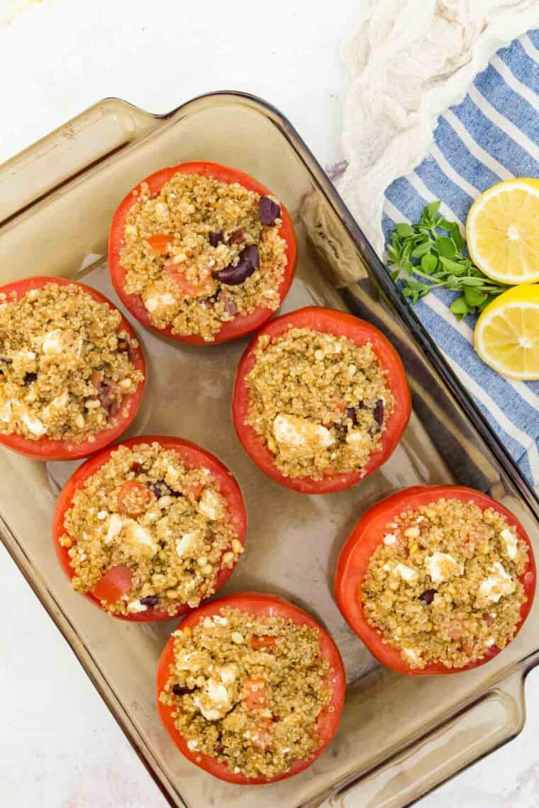 A baking dish of quinoa stuffed tomatoes topped with feta cheese.