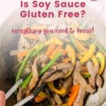 Beef stir fry in a wok being tosses with tongs with text that says "Is Soy Sauce Gluten Free? Everything You Need to Know."