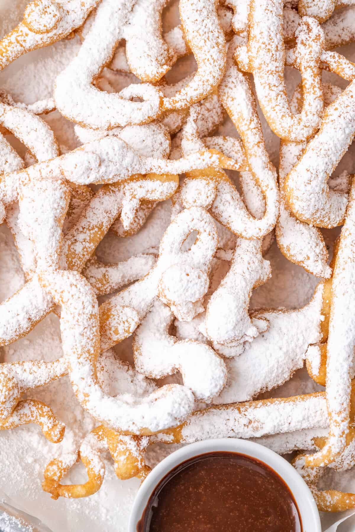Close up of funnel cake fries dusted with powdered sugar.