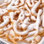 Close up of funnel cake fries dusted with powdered sugar.