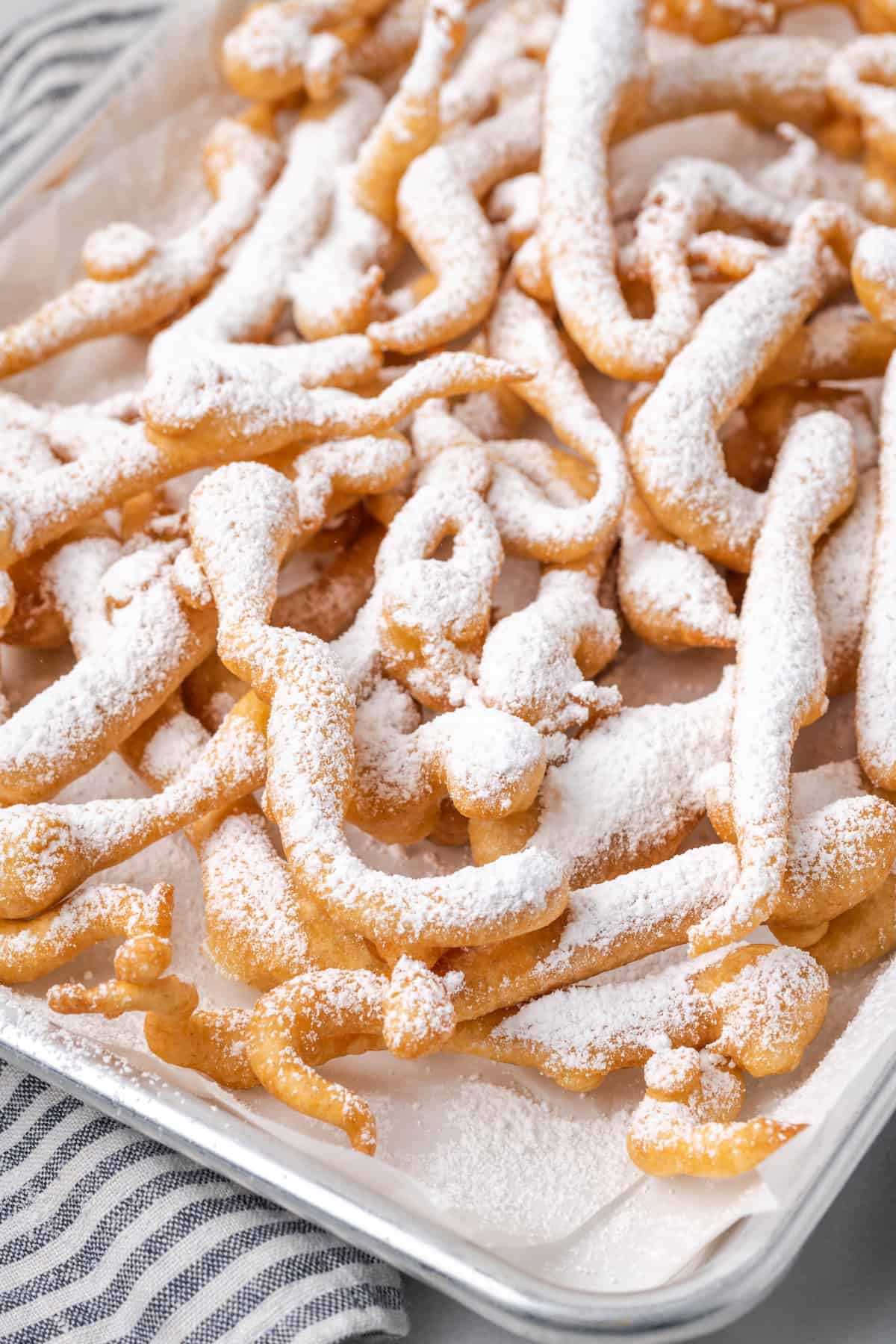 Close up of funnel cake fries dusted with powdered sugar.