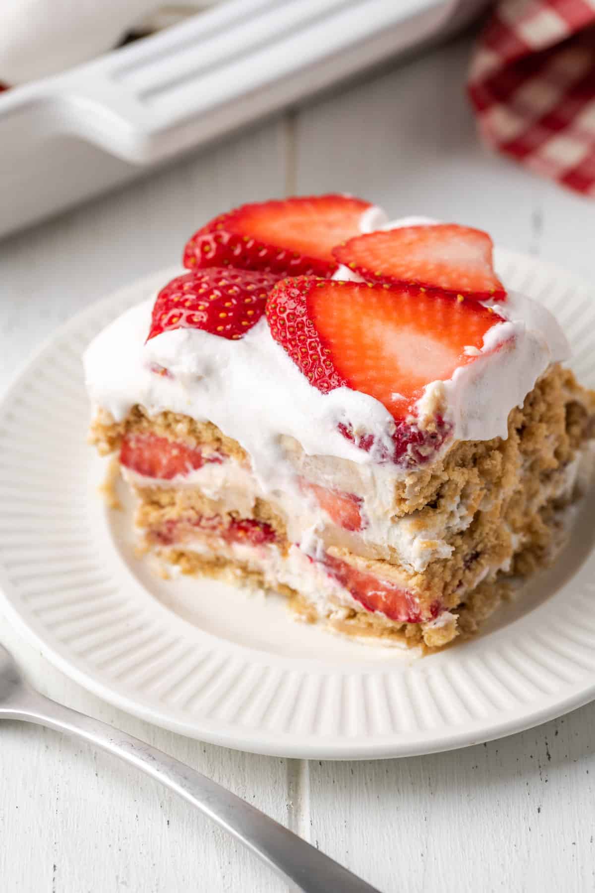A slice of gluten-free strawberry icebox cake on a white plate.