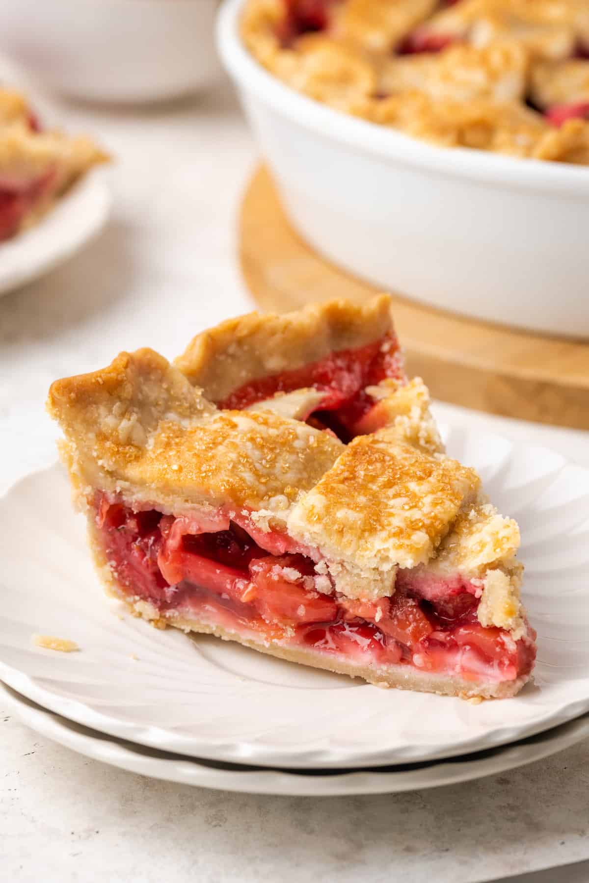 A slice of strawberry rhubarb pie on a white plate.