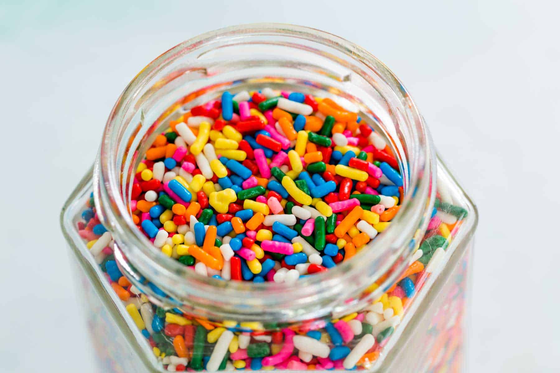 A glass jar of rainbow sprinkles.