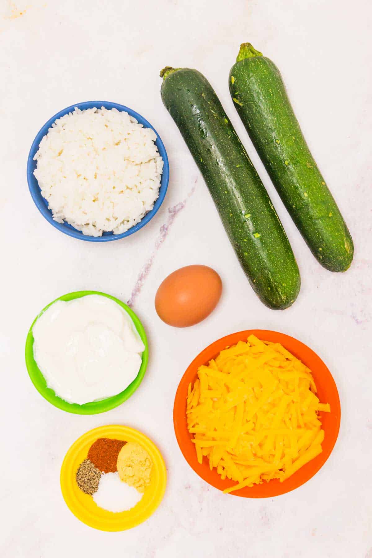 Ingredients for a zucchini casserole on a marble countertop.
