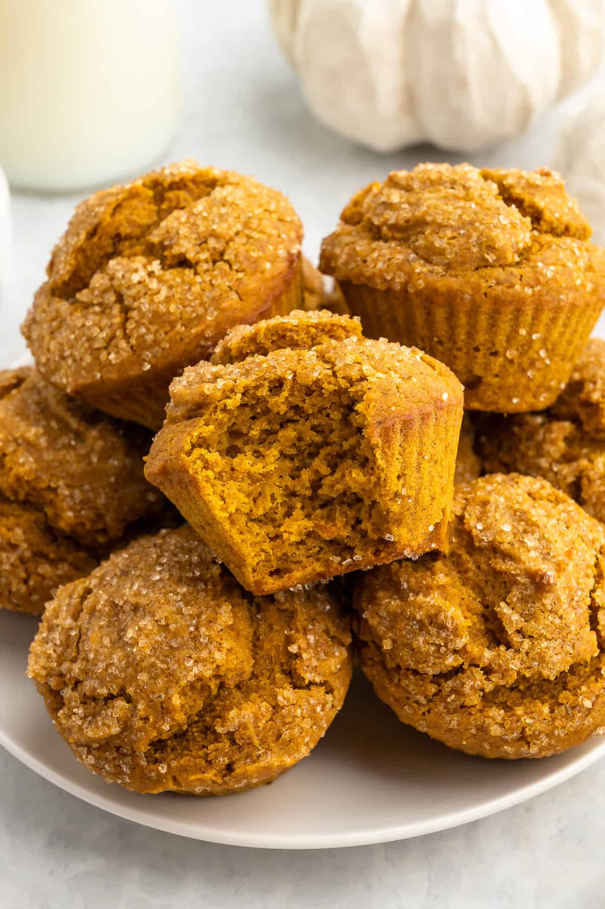 A plate of gluten-free pumpkin muffins with a bite taken out of one.