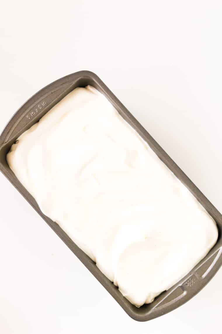 A loaf pan with unfrozen cheesecake ice cream base.