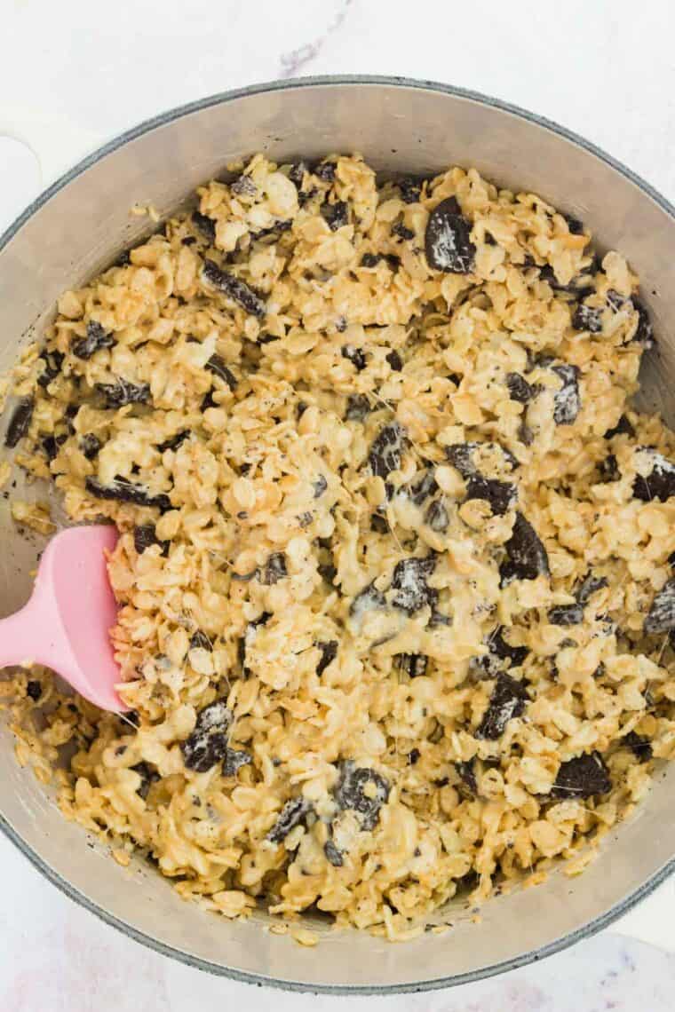 A spatula mixes together the batter for Oreo Rice Krispies treats.