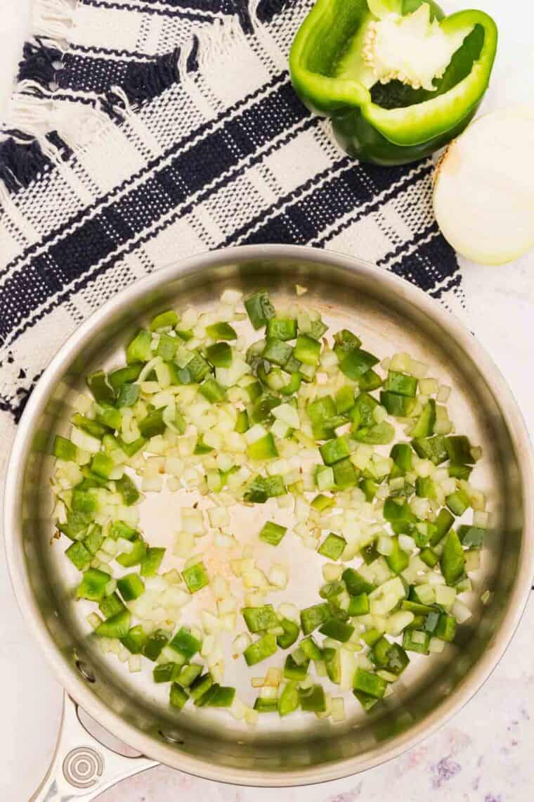 Cooking onions and garlic in a metal pan.