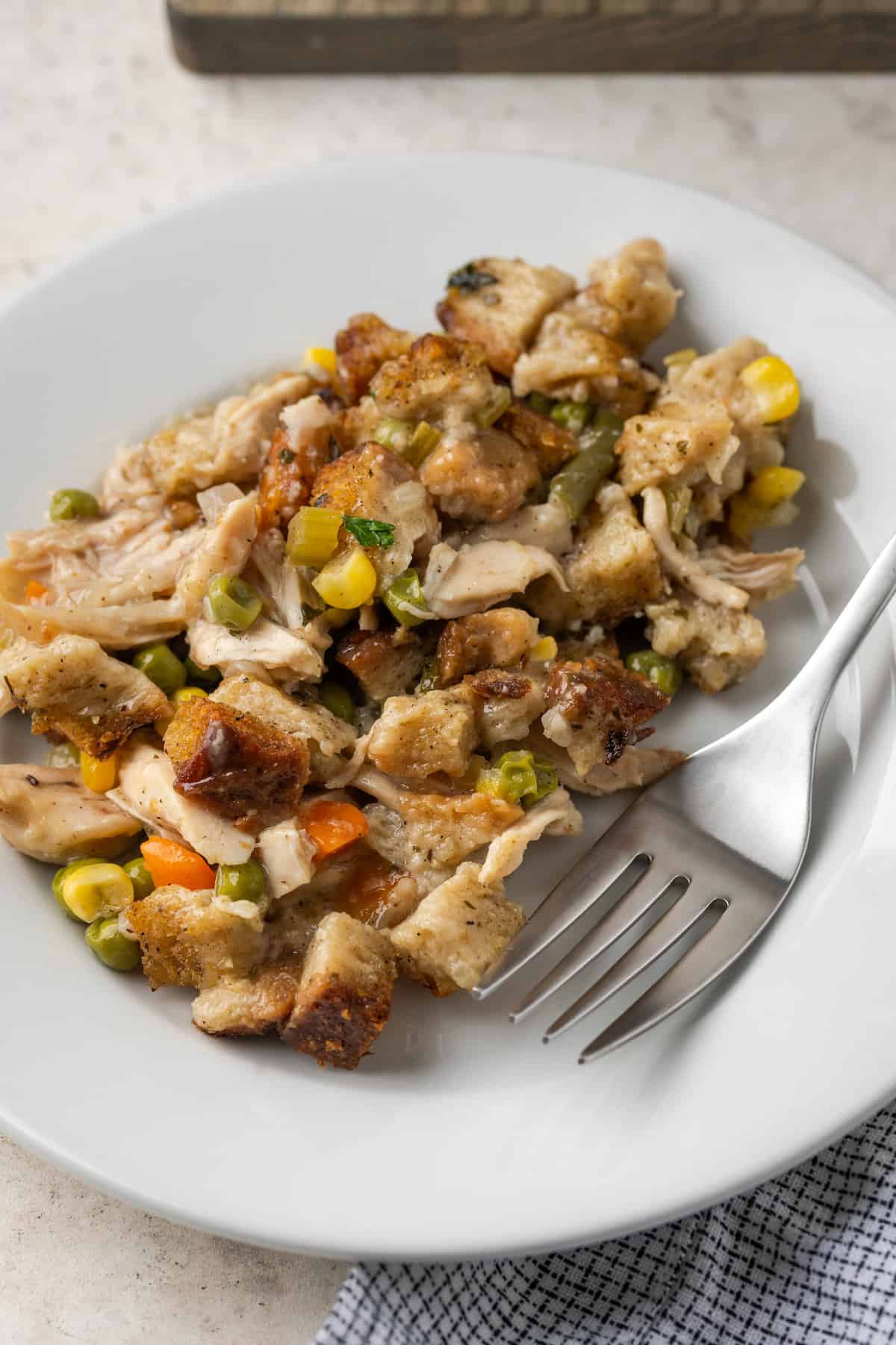 A plate of chicken stuffing casserole with a fork.