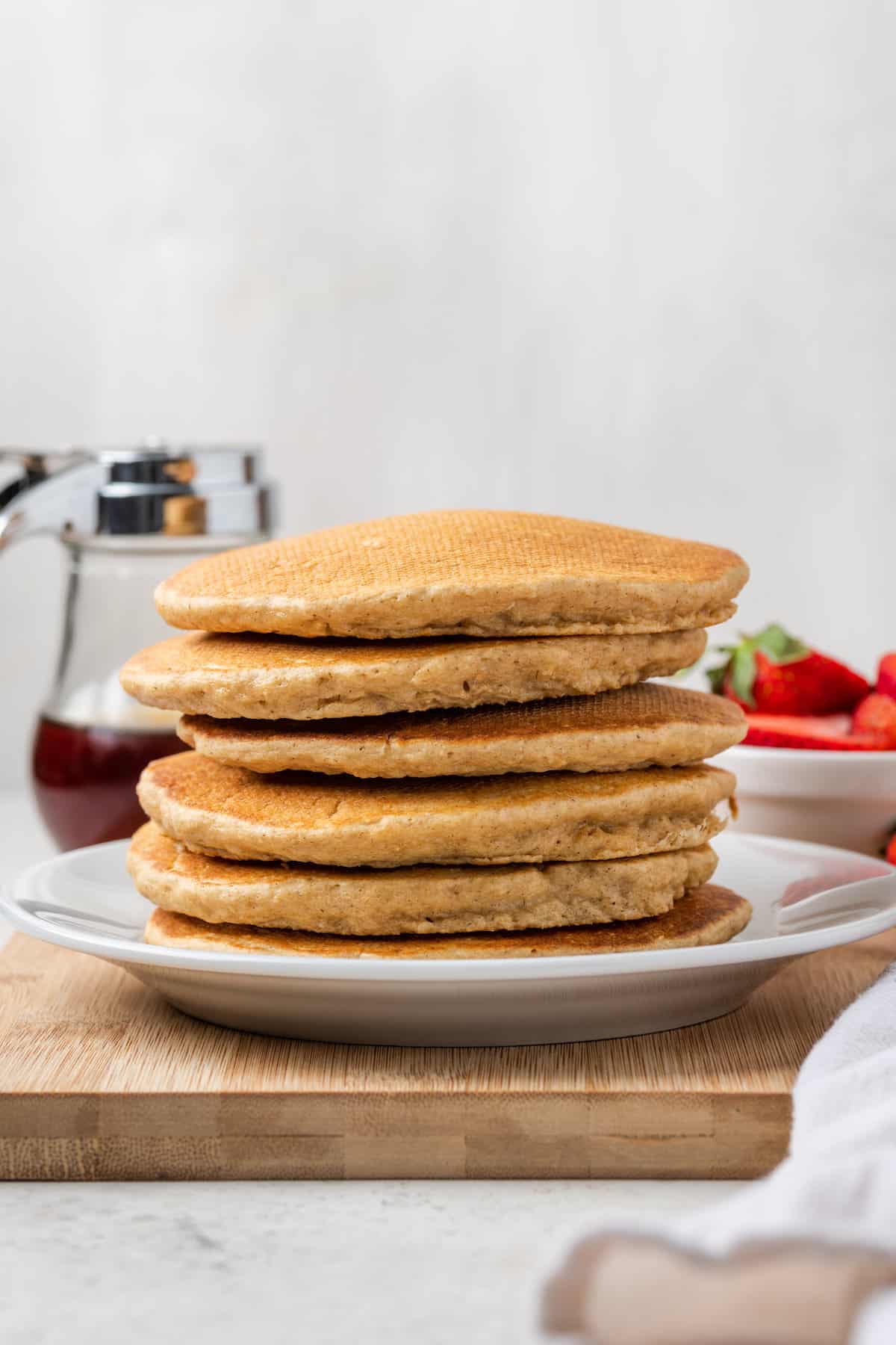 A stack of oatmeal pancakes on a white plate.