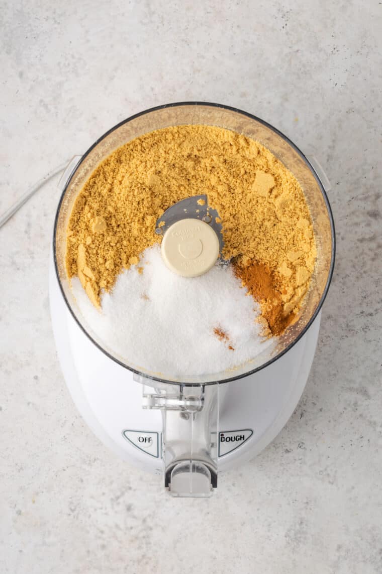 Making a cookie crust with sugar and graham crackers in a food processor.