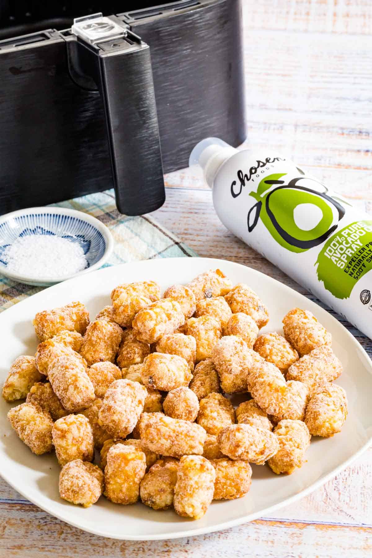 Ingredients for air fryer tater tots are shown: frozen tater tots, oil, and salt.