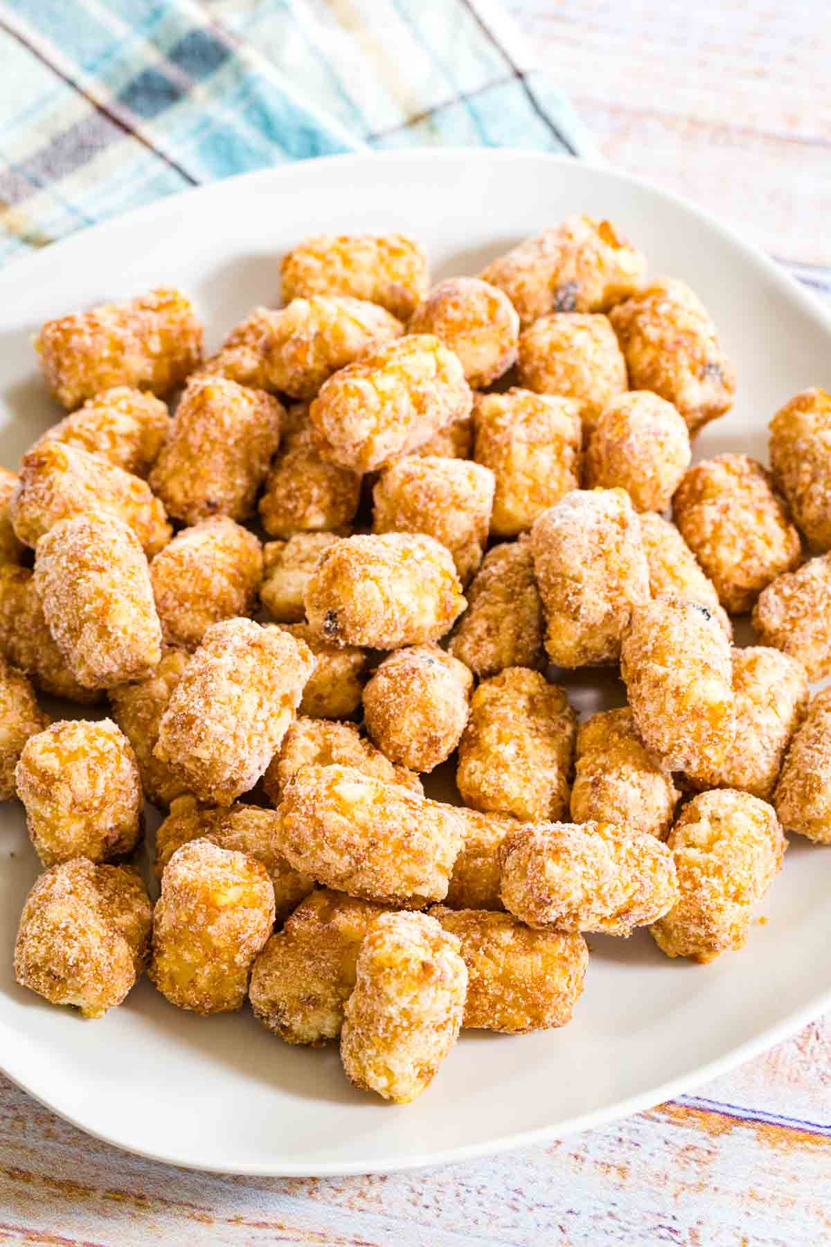 Frozen tater tots are shown on a white plate.