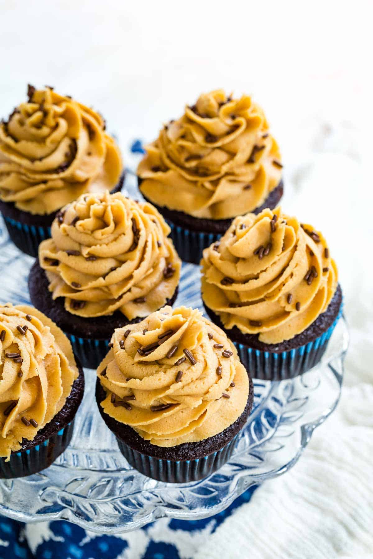 Gluten free chocolate cupcakes are shown topped with peanut butter frosting.