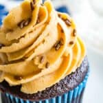 A gluten free chocolate cupcake is shown topped with peanut butter frosting.