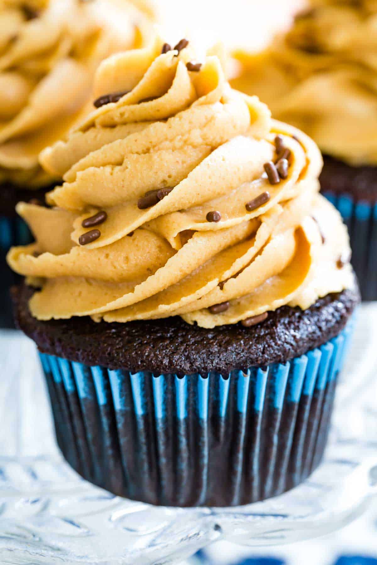 A gluten free chocolate cupcake is shown topped with peanut butter frosting.