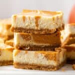 A stack of three pumpkin swirled cheesecake bars with text overlay that says "Gluten Free Pumpkin Cheesecake Bars".