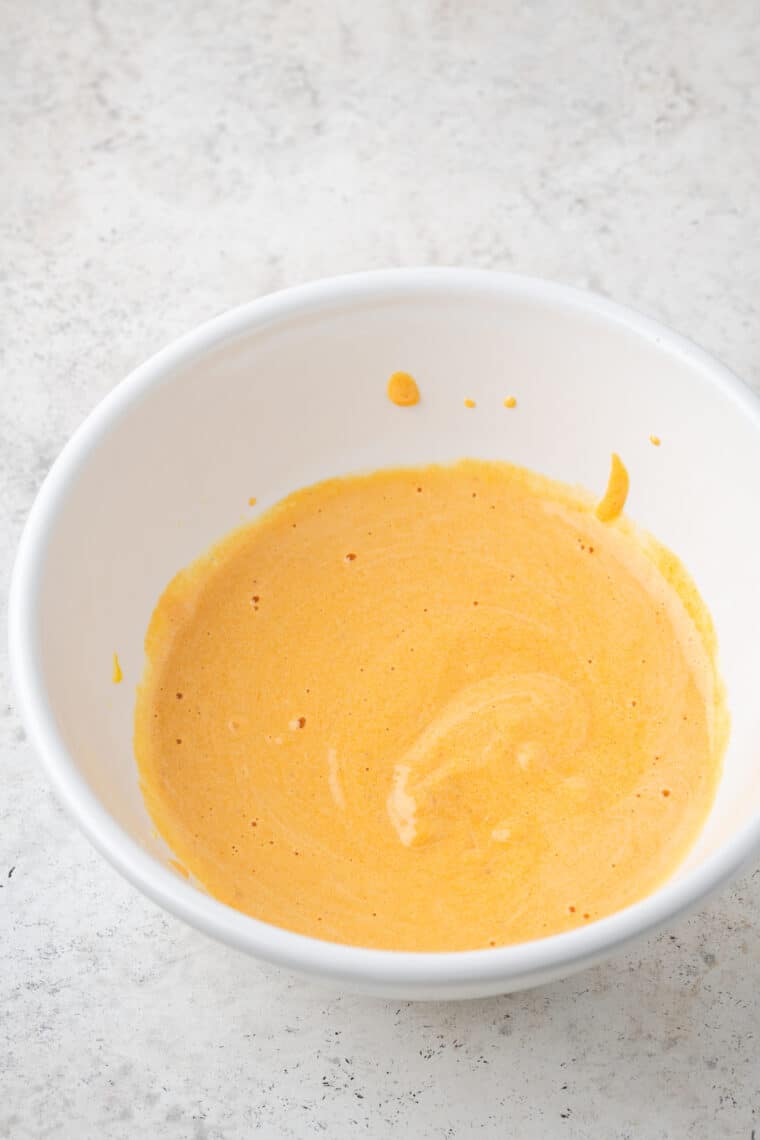 Pumpkin puree plus other ingredients are seen in a white bowl.