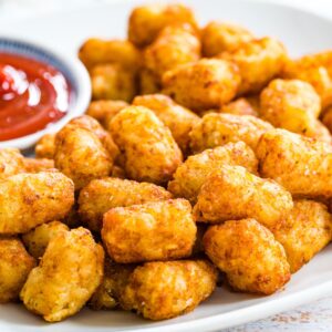 Crispy and golden-brown tater tots piled on a plate.