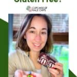 A woman holding a bag of M&M's in one hand and some of the candies in the other on a green and white background with text overlay that says "Are M&M's Gluten Free?".