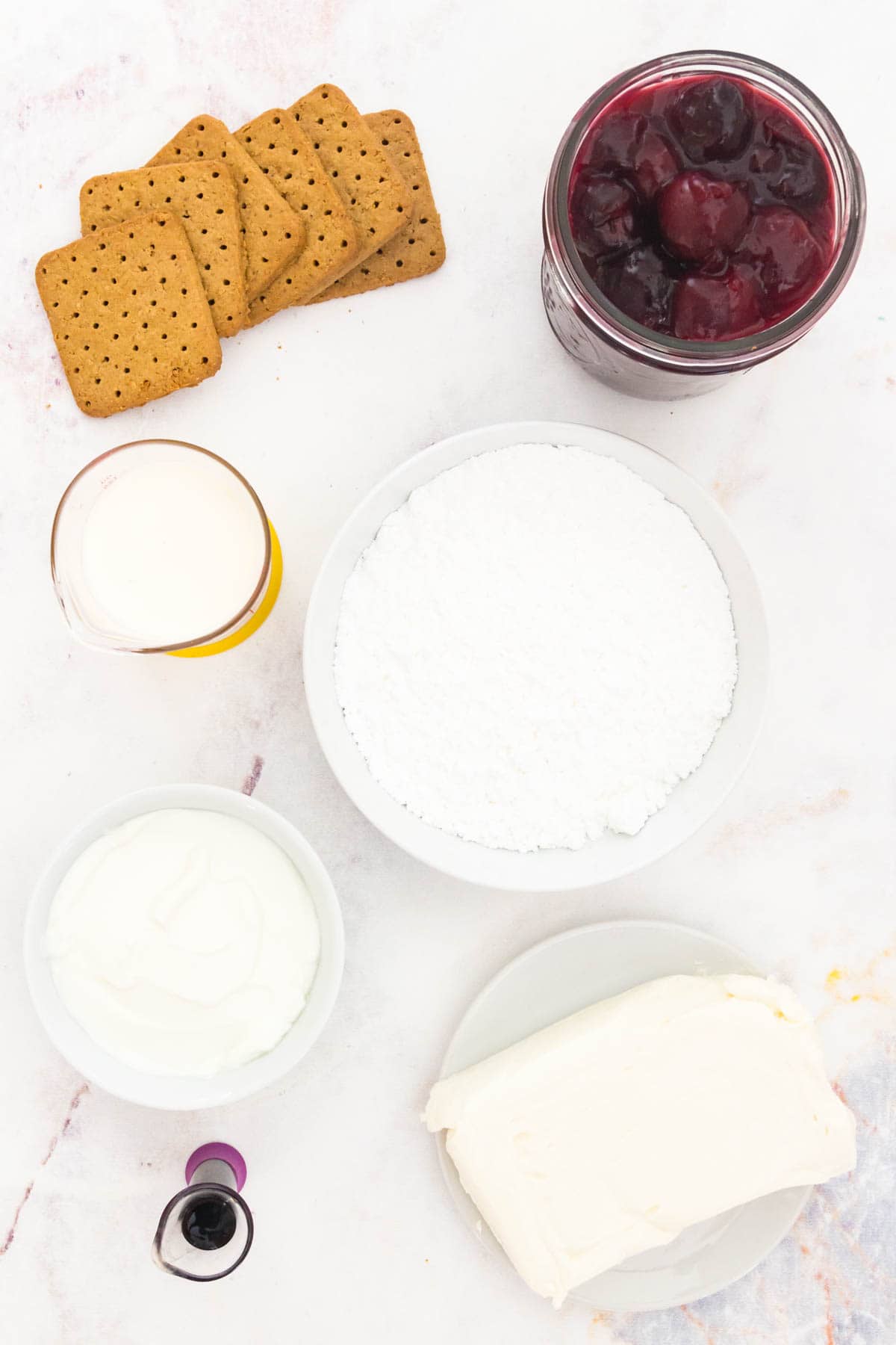 Ingredients for cherry cheesecake dip are shown in bowls: cream cheese, yogurt, crackers, sugar, cherries.